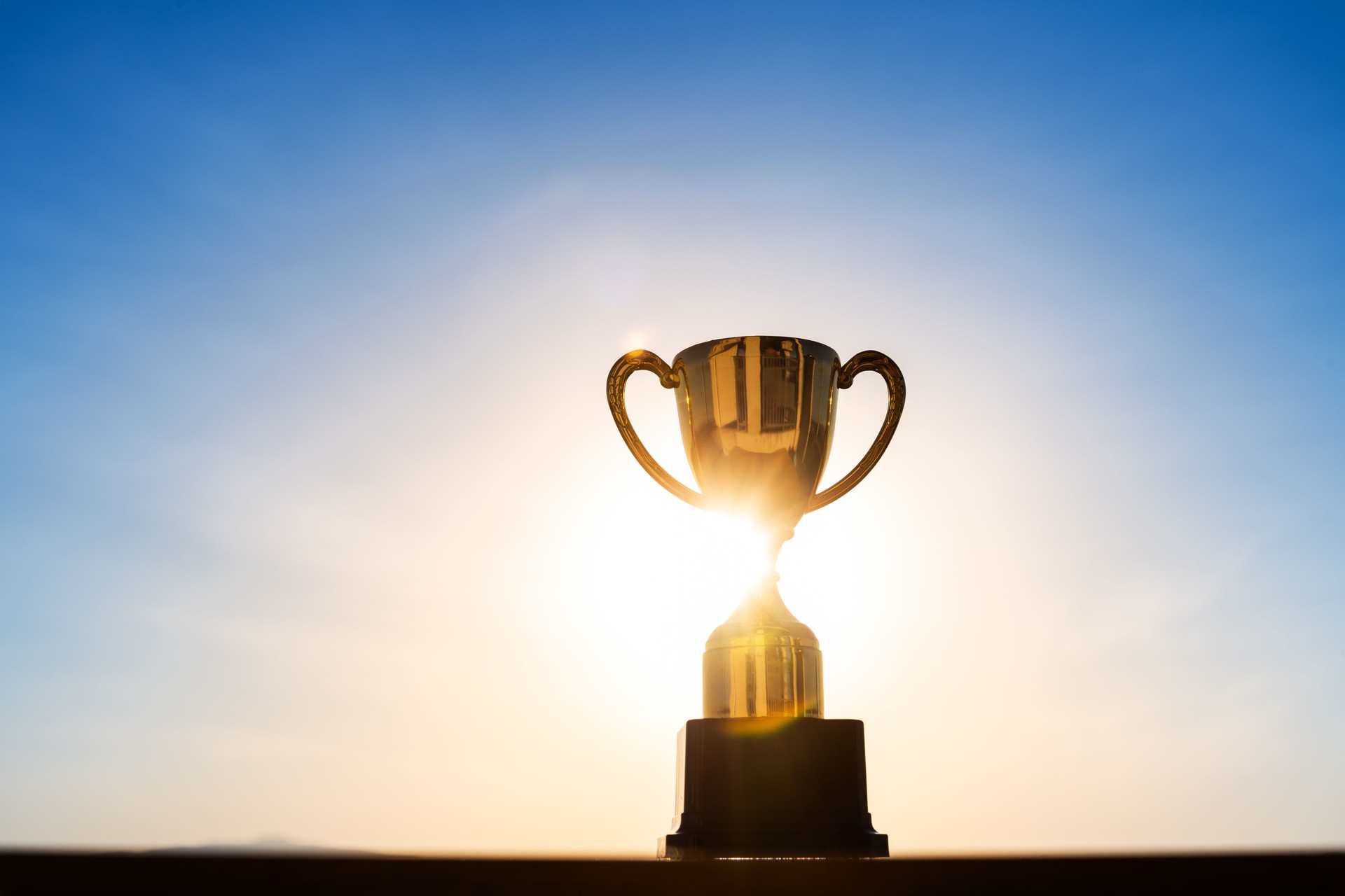 Single winner trophy on sunset sky background